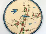 une assiette ornée d'oiseaux et de fleurs sur un fond blanc