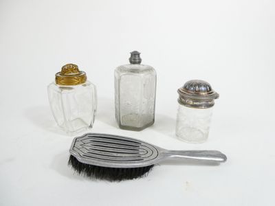 three salt and pepper shakers and a brush on the table