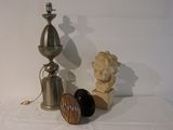 une lampe, un bougeoir et une statue posés sur une table