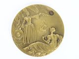 a gold medal with a woman and a bird on it