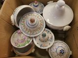 une boîte en carton remplie de nombreuses pièces de poterie de toutes sortes