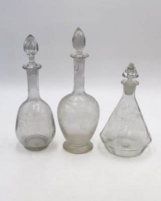 trois carafes en verre transparent avec un bouchon en argent et un bouchon en argent