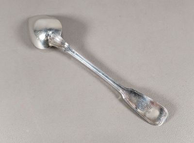une cuillère en argent avec un manche de cuillère sur une surface blanche