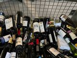 many bottles of wine in a wire basket on the floor