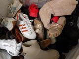 many pairs of shoes that are sitting on a bed