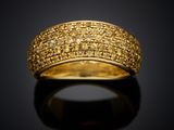 a gold ring with yellow diamonds on a black surface