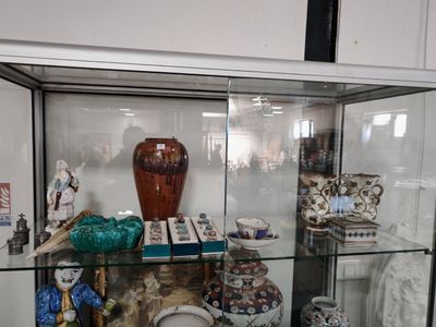 a glass display case with a lot of vases on it
