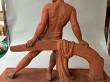 statue of a man sitting on a bench with a horse