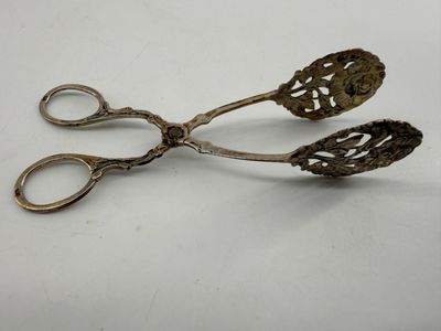 pair of antique silver scissors on white surface with white background