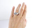 a woman ' s hand holding a ring with a pearl on it