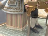 une figurine représentant une femme assise à une table