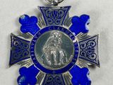 a close up of a blue cross with a silver medal on it