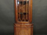a wooden corner cabinet with glass doors and a glass door