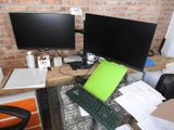 a desk with two computer monitors and a keyboard on it