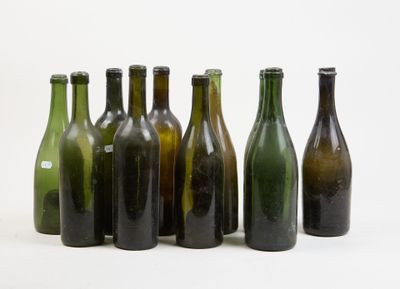 plusieurs bouteilles de vin vides alignées en rang sur une surface blanche