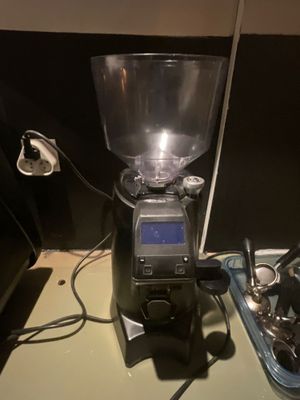 a coffee grinder sitting on top of a counter next to a bowl