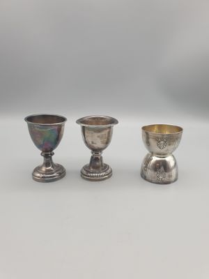 trois gobelets en argent posés les uns à côté des autres sur une table