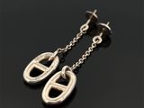 une paire de boucles d'oreilles en argent posées sur une surface noire