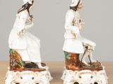 pair of porcelain figurines of a woman and a man sitting on a bench