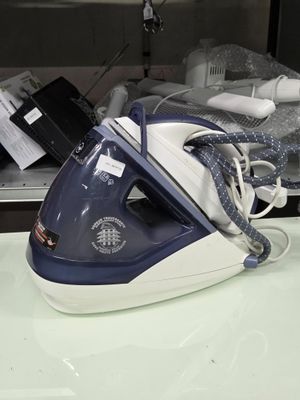 un fer à repasser à vapeur bleu et blanc posé sur un plan de travail