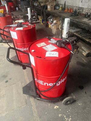 several red barrels are lined up in a row in a garage