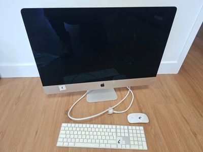 a computer monitor, keyboard and mouse on a wooden floor