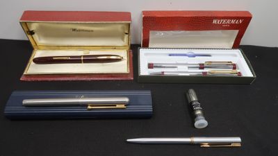 three pens and a pen in a box on a table