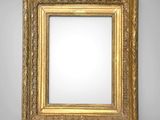 a gold framed mirror on a wall with a white background