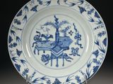 a blue and white plate with a picture of a man on a horse