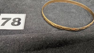 un gros plan d'un bracelet en or portant le chiffre 78