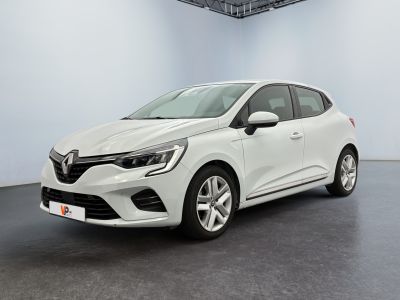 Une voiture blanche est garée dans une pièce au sol noir.