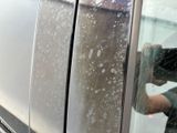 a man taking a picture of himself through the window of a car