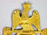 a gold eagle with a crown on top of a plaque