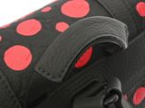 the back of a black and red polka dot purse with a red handle