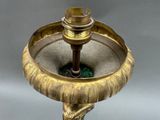 a gold plate with a candle on top of it