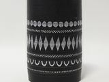une image représentant un vase noir orné d'un motif blanc