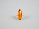une bague ovale en verre ambré ornée d'une bande dorée