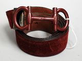 une ceinture rouge avec une boucle métallique sur un fond blanc