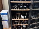 many bottles of wine on the shelves in the wine cooler