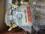 a bottle of perfume sitting on a table next to a glass