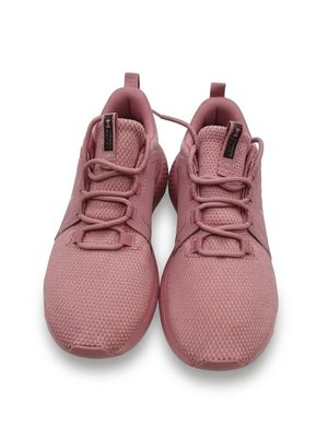 Les baskets roses des enfants sont posées sur une surface blanche