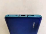 the back of a blue phone sitting on top of a white table