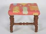 an image of a small wooden stool with a colorful upholstered seat