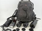 un sac à dos contenant un appareil photo, un objectif et d'autres objets