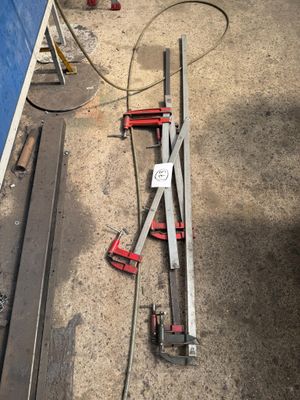 Il y a des outils posés par terre près d'un mur bleu.