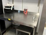 a kitchen with a table and a refrigerator in it