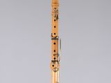 an orange and black clarinet on a clear stand