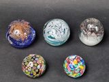 six glass marbles sitting on top of a table next to each other