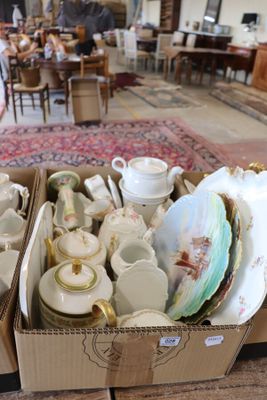 two boxes full of tea cups and saucers on a table