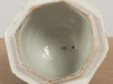 a small white vase sitting on top of a table